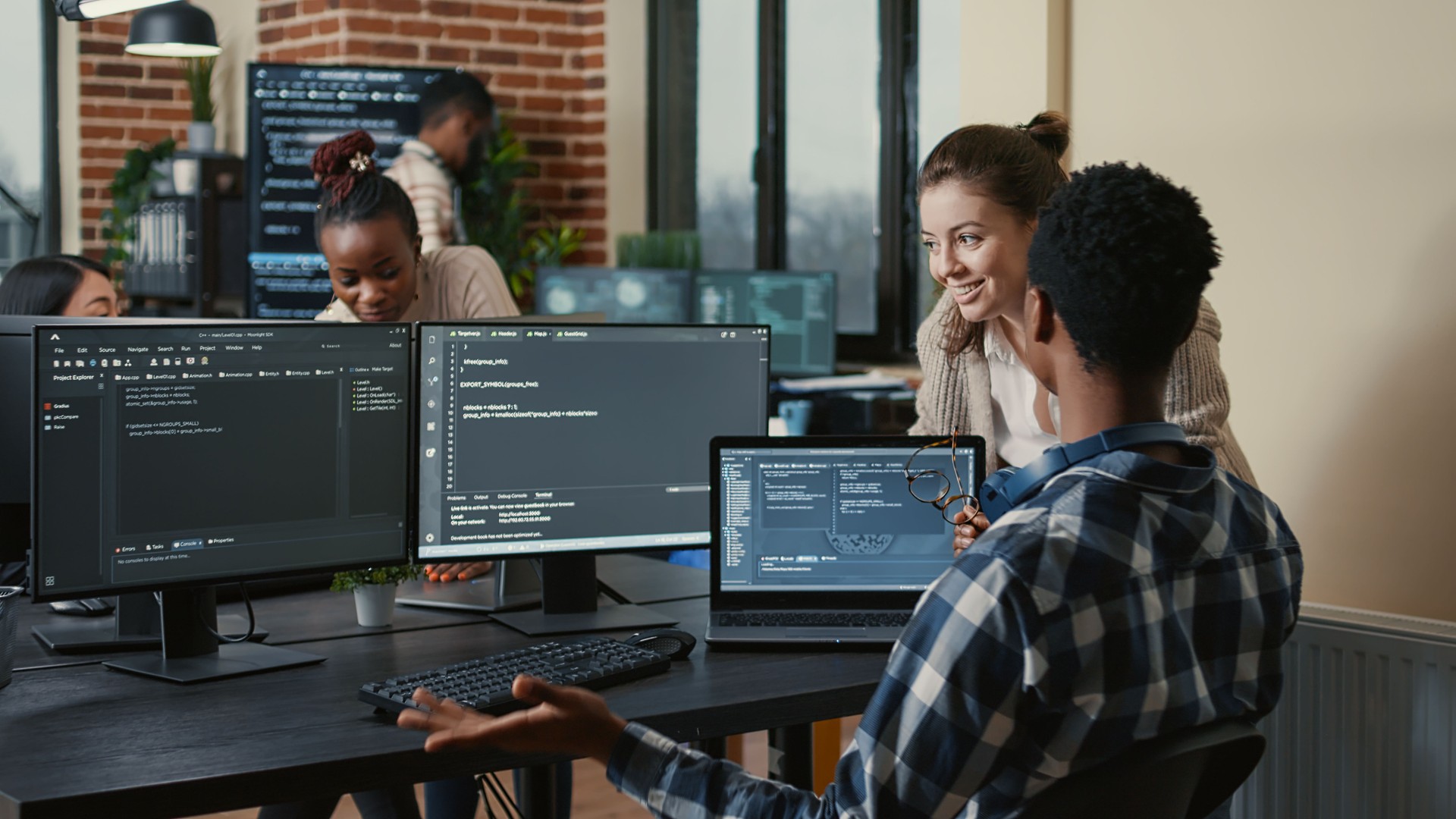 Software developers celebrating successful code compiling doing high five hand gesture